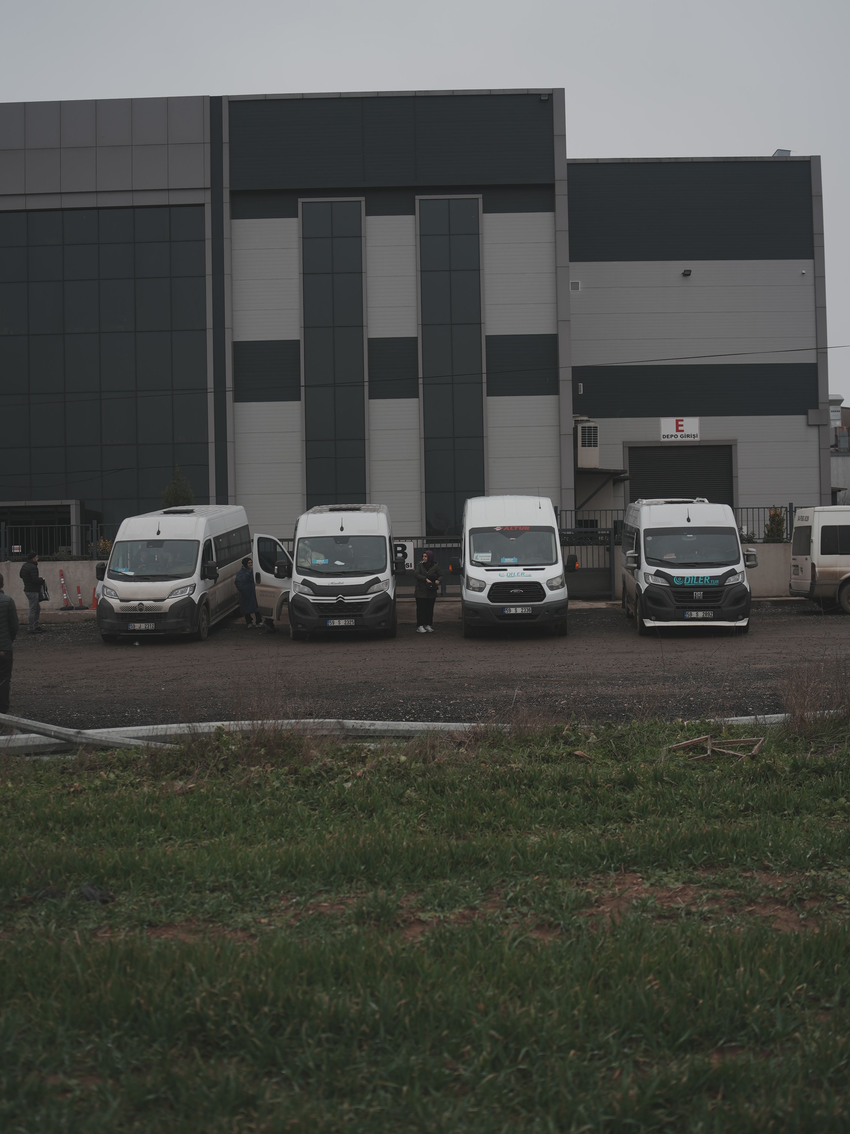 Fabrika binasının önünde sıralanmış dört Diler Tur servis aracı
